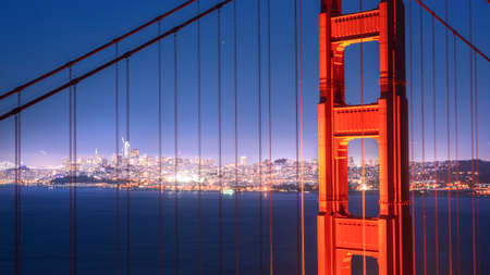 First tower of the Golden Gate Bridge and San Francisco Downtown in the night