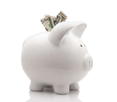 White piggy bank with money isolated on white backgroundの写真素材