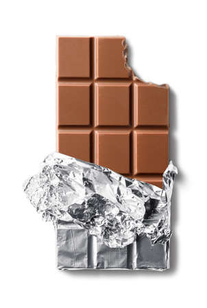 Top view of bitten milk chocolate bar in foil. Isolated on white background