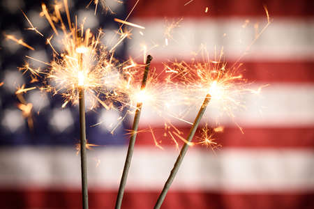 Sparklers Closeup With American Flag In Background. Celebrating 4th Of July Independence Dayの写真素材
