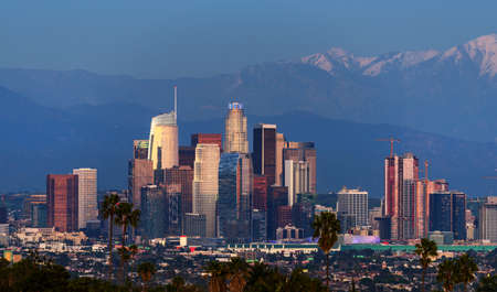 Downtown Los Angeles skyline with snow capped mountains behind at twilightの写真素材