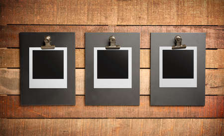 Three blank photos on wooden backgroundの写真素材