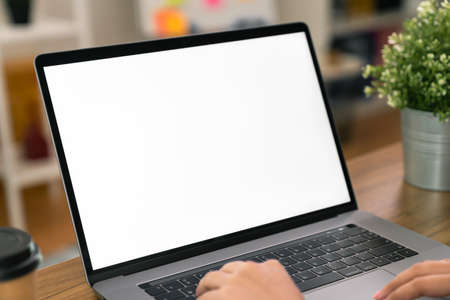 Hand using a computer laptop with a blank screen on table, for putting advertising to promote.