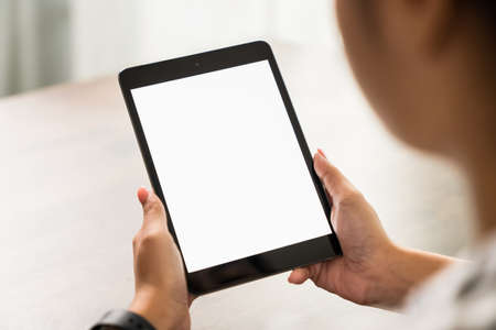 Young woman holding digital tablet with a blank screen on table, for putting advertising to promote.の写真素材