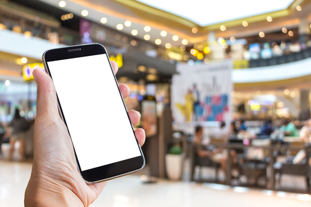 Asian women hand holding mobile phone screen blank background blur bokeh at a coffee shop in the department stores.の写真素材