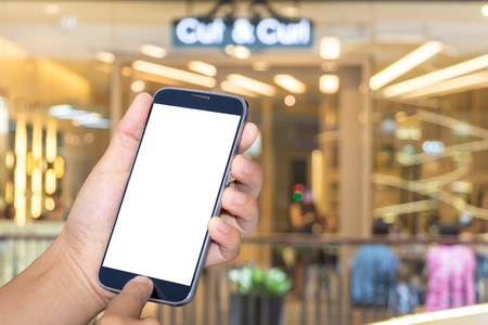 Asian women hand holding mobile phone screen blank background blur bokeh at a coffee shop in the department stores.の写真素材