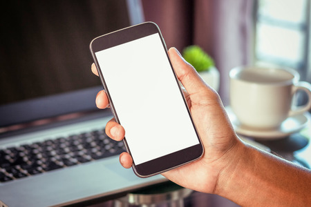 Close Up of woman hands using mobile phone and laptop computer with blank copy space screen for your advertising text message or content business in the Vintage effect.の写真素材