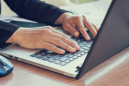 Close Up of woman hands using mobile phone and laptop computer with blank copy space screen for your advertising text message or content business in the Vintage effect.の写真素材