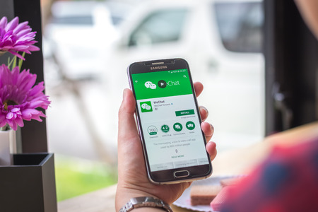 Chiang Mai, Thailand - September 12, 2017: Samsung Galaxy S6 smartphone launches wechat application on the desk screen at the coffee shop.のeditorial素材