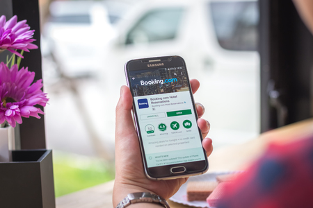 Chiang Mai, Thailand - September 12, 2017: Samsung Galaxy S6 smartphone launches booking com application on the desk screen at the coffee shop.のeditorial素材