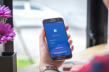 Chiang Mai, Thailand - September 12, 2017: Samsung Galaxy S6 smartphone launches faceebook application on the desk screen at the coffee shop.のeditorial素材