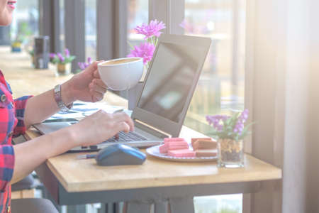 Close Up businessmen working at a coffee shop with a document with a smartphone and a laptop computer.の写真素材