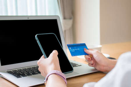 Businessman hands touch on the mobile and paying with credit card online while making order online shopping via the internet.の写真素材