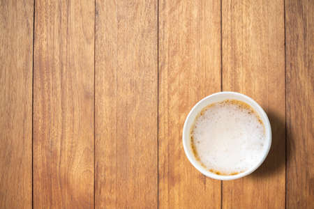 A bird's-eye view of black coffee is placed on a wooden table in the morning with copy space.