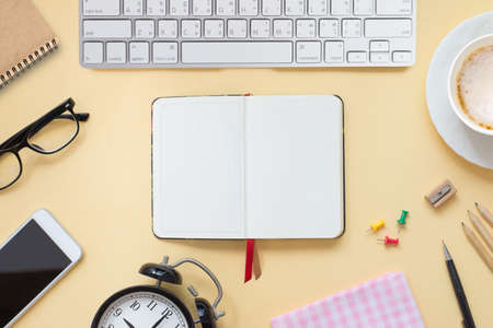 Top view of student desk with laptop, smartphone, pencil, earphones, cup of coffee get ready for online courses with copy space. You can write and take note of important content in note book.の写真素材