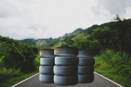 New tires from the factory is placed on a country road on top of the mountain in the forest. Demonstrates readiness to travel in all road conditions.の写真素材