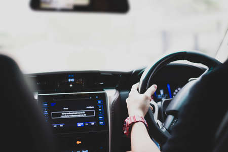 He was driving and hand holding on the steering wheel. He used his car as a carrier to work from home to the company in the center of the city. She had to drive through a traffic jam in the morning.の写真素材