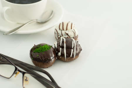 Chocolate donuts with coffee on table
