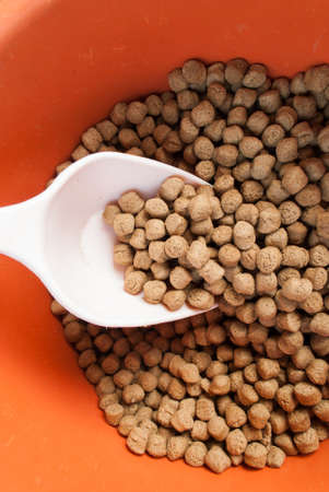 fish feed in orange plastic container