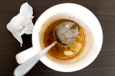 Used coffee mug and Tissue on a wooden tableの写真素材