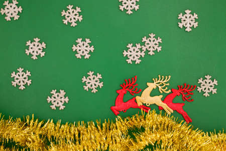 reindeer toy, snow and fir decoration for winter holidays, on green background, decorating home at Christmastimeの写真素材