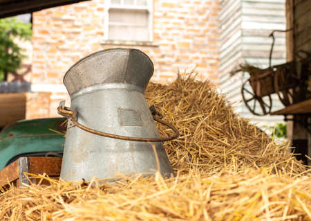 Old milk can on strawの写真素材