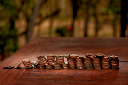 Thai bath coin 25 satang lots on wooden table with blurred background, Money of Thailand, Investment and saving concept, Money stack for business planning investmentの写真素材