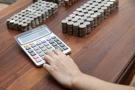 Business woman counting lots stack coins on wooden desk background texture, Money for business planning investment and saving conceptの写真素材