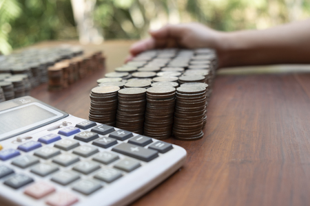 Business woman counting lots stack coins on wooden desk background texture, Money for business planning investment and saving conceptの写真素材