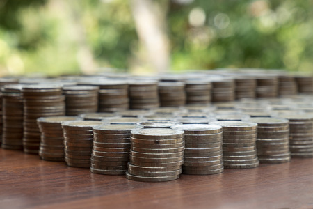 Lots stack coins on wooden desk with blurred background texture, Money for business planning investment and saving conceptの写真素材