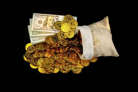 Stack bundles of 100 US dollars banknotes and gold coin in treasure sack on black background, Money stack for business planning investment and saving future conceptの写真素材