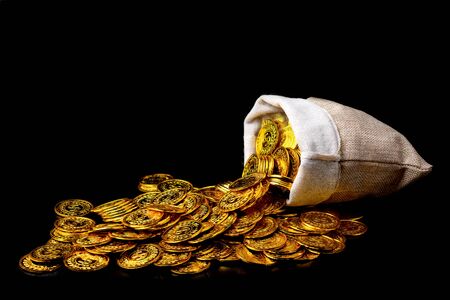 Stacking gold coin in treasure sack on black background, Money stack for business planning investment and saving future conceptの写真素材