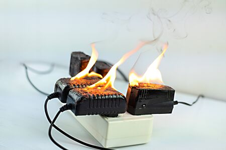 On fire adapter at plug Receptacle on white background, Electric short circuit failure resulting in...