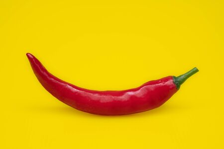 Close up red Hot chili spur pepper at yellow backgroundの写真素材