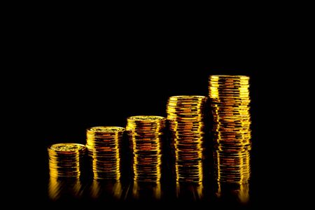 Lots of stacking gold coin at black backgroundの写真素材