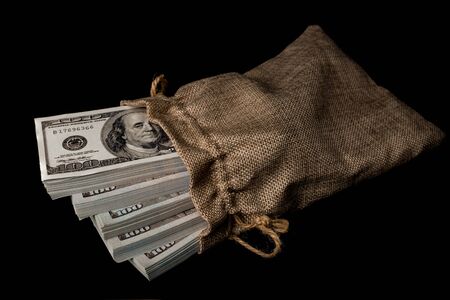 Sack of money 100 USD dollars banknotes a lot of money at black backgroundの写真素材