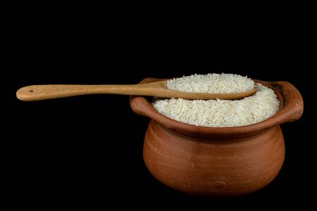 Jasmine rice in a clay pot and the wood ladle isolated on white backgroundの写真素材