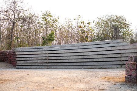 Stacked concrete electric pole on the ground prepare to useの写真素材