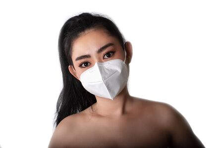 Close up of a woman putting on a respirator N95 mask to protect from airborne respiratory diseases as the flu covid-19 coronavirus ebola PM2.5 dust and smog, Safety virus infection concept,の素材 [FY310142526902]