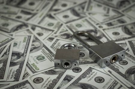 Iron lock key on the group of money stack of 100 US dollars banknote a lot of the background texture, top viewの写真素材