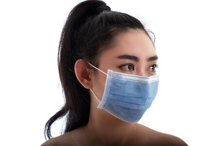 Beautiful young Asia woman putting on a medical mask to protect from airborne respiratory diseases as the flu covid-19 PM2.5 dust and smog, Women safety virus infection conceptの写真素材