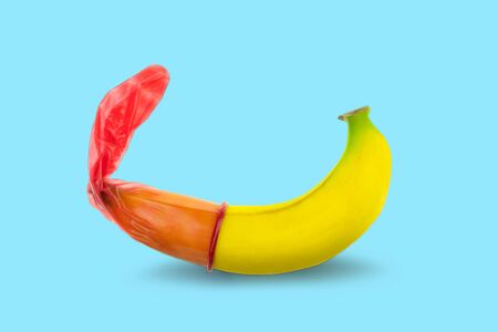 Red condom wear a banana on blue background, Safe Sex prevention of sexually transmitted diseases and contraceptive concept, with clipping Pathの写真素材