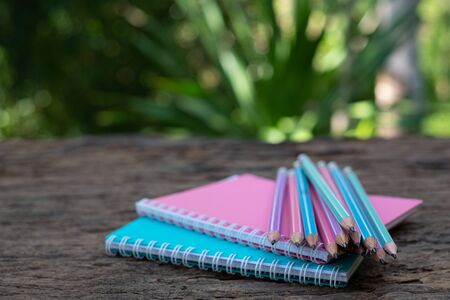 Pencil on top of book mockup on the old wood desk at blurred the backgroundの写真素材