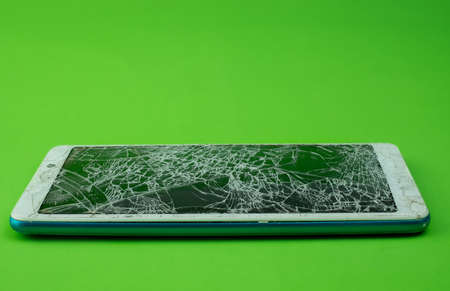 Smartphone screen is cracked on green backgroundの写真素材