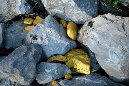 Gold nugget and grey granite stone background