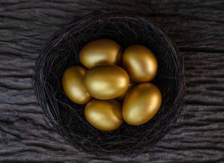 Golden eggs in a nest on the old wood table
