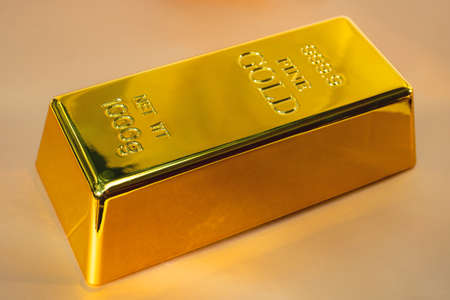 Closeup shiny a gold bar 1 kg on yellow background