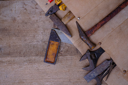 Collection of woodworking old hand tools in leather apron on a rough workbench wooden