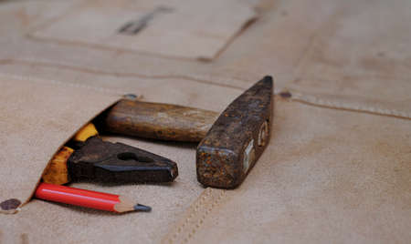 Collection of woodworking old hand tools in leather apron on a rough workbench wooden