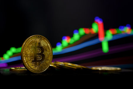 Golden bitcoin cryptocurrency at trading chart backgroundの写真素材